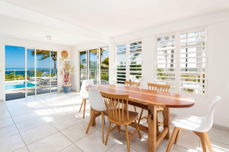 Salle à manger baie coulissante et jalousies vue mer piscine et palmiers — Pose 24 Martinique