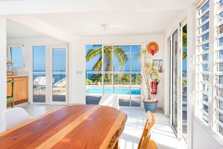 Fenêtre PVC blanche jalousies au-dessus plan cuisine vue mer et îlot — Pose 24 Martinique