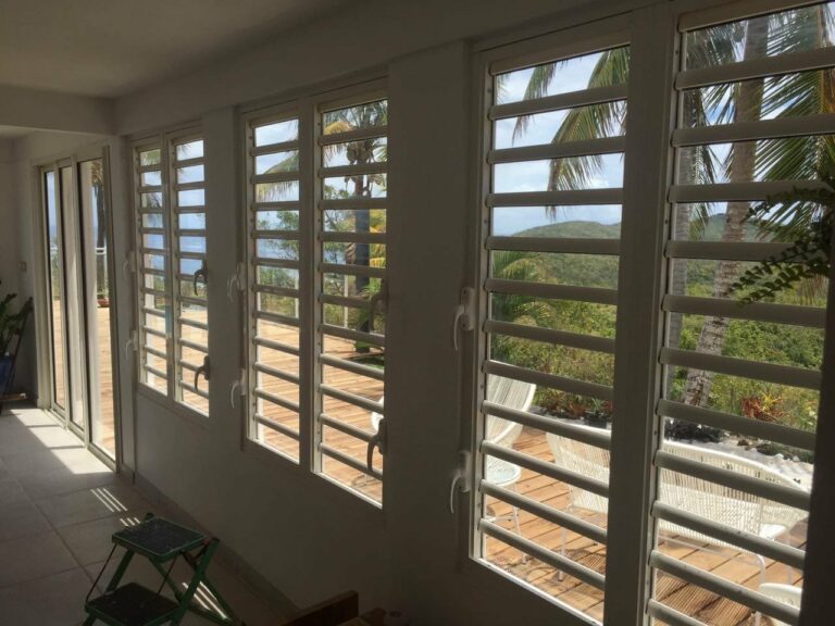 Véranda fermée fenêtres à jalousies blanches orientables vue palmiers — Pose 24 Martinique