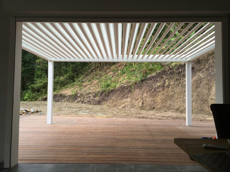Pergola bioclimatique blanche lames orientables sur terrasse bois en chantier — Pose 24 Martinique