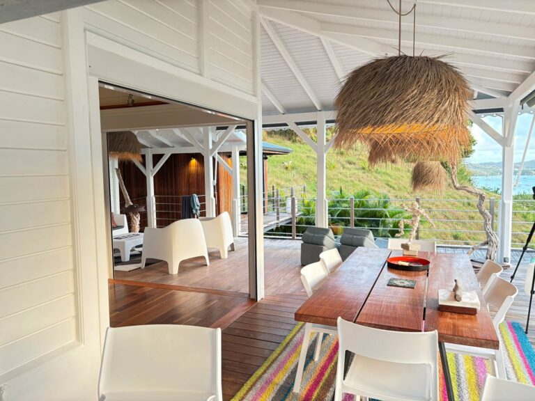 Sous pergola lames bois clair terrasse bois piscine et vue mer haut de gamme — Pose 24 Martinique
