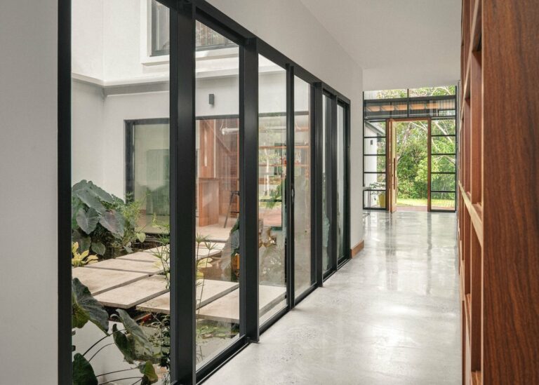 Façade villa moderne avec volets roulants alu anthracite à lames orientables terrasse pierre — Pose 24 Martinique